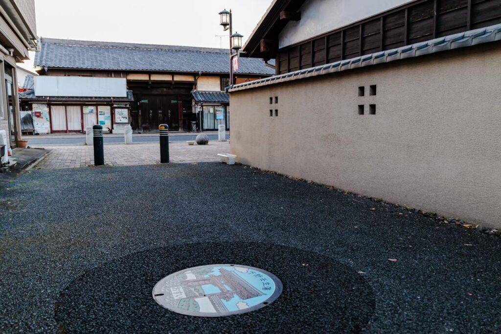 壬生町A「下野壬生藩」のデザインマンホール蓋と設置場所の周囲がわかる現地の様子