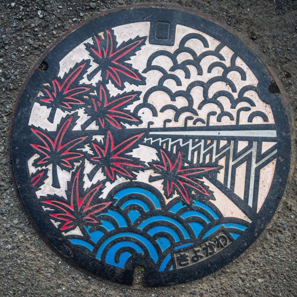 イロハモミジと虹の大橋がデザインされた実物マンホール蓋